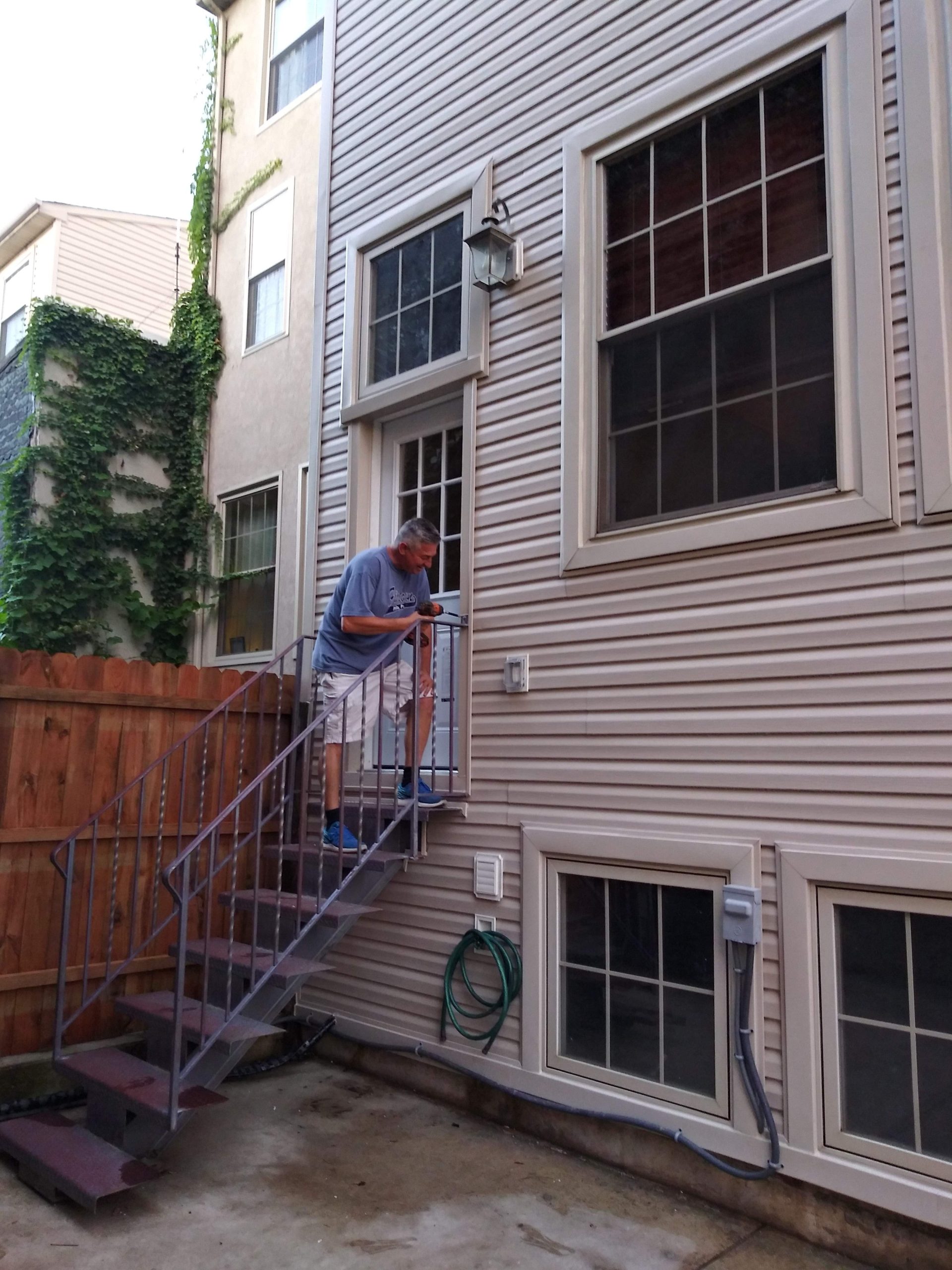 Worker putting finishing touches on an exterior home rebuild.