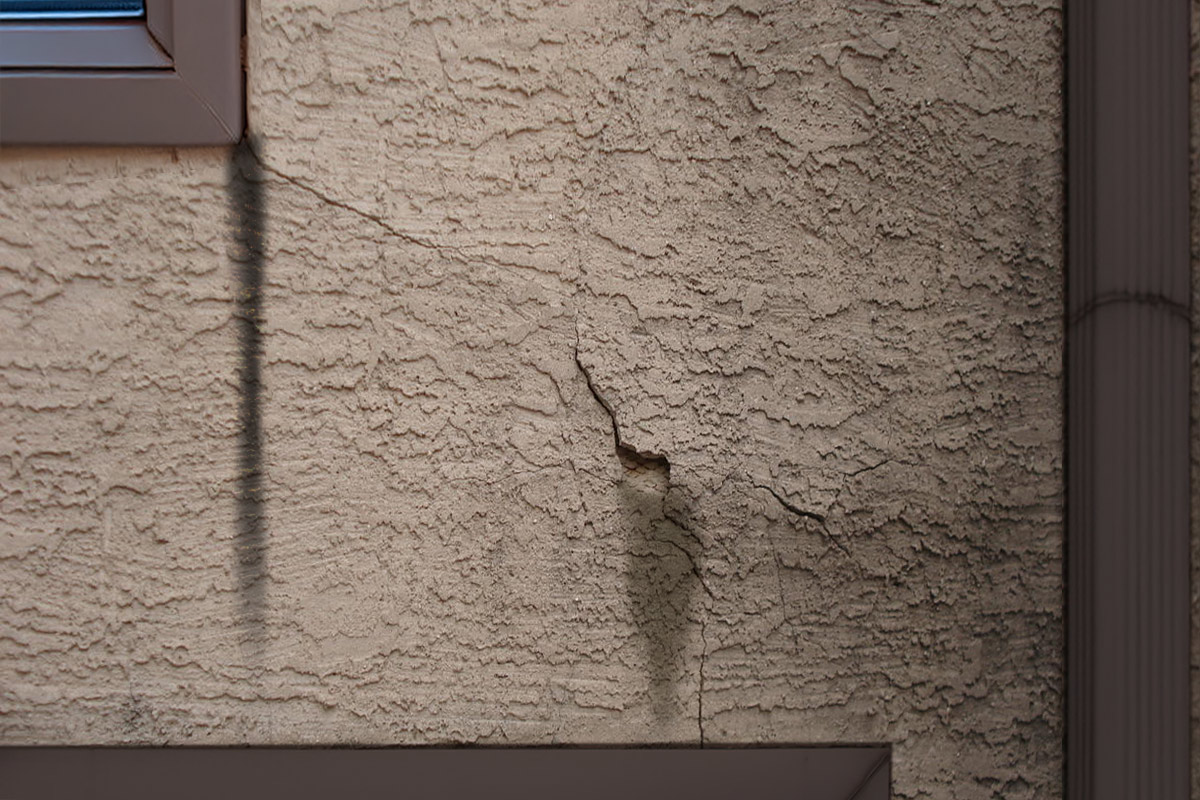 Cracks, staining, and crumbling stucco showing how rain intrudes on your home.